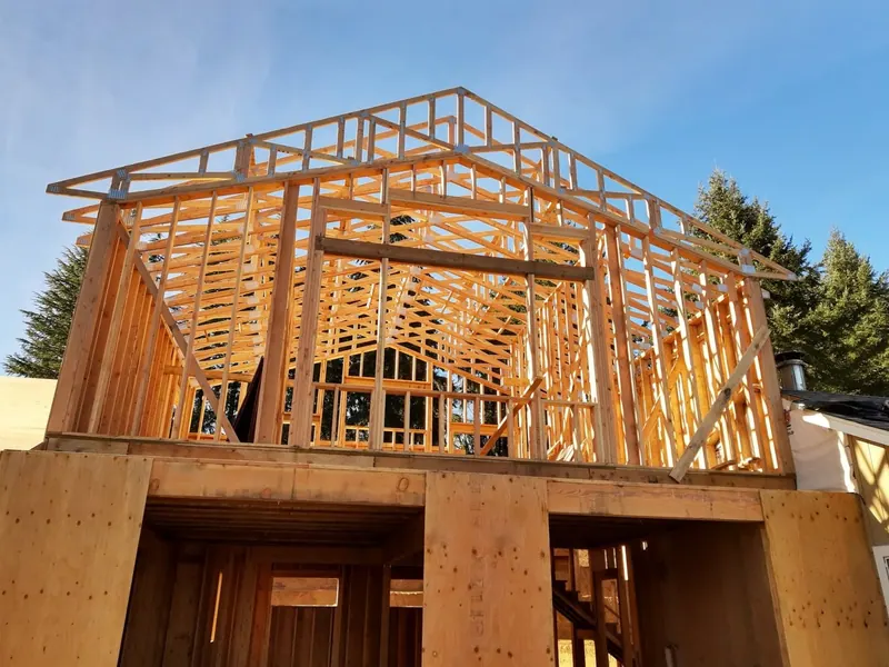 Close-up of intricate roof truss framing for a new two-story garage and ADU build in Eugene, Oregon by Red Umbrella.
