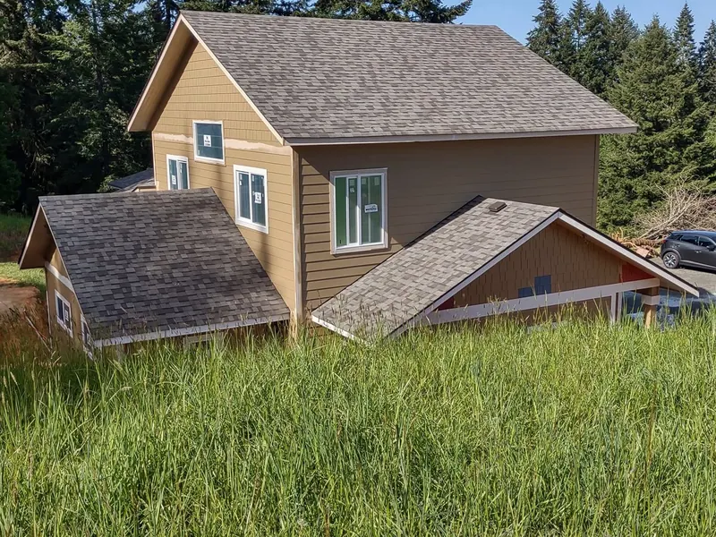 Finished two-story garage and ADU with tan siding and grey shingle roof built by Red Umbrella in the Eugene, Oregon area.